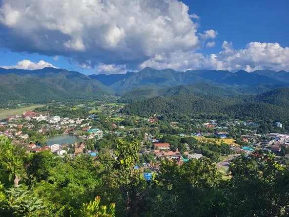 Elevated view of a town situated between green mountains