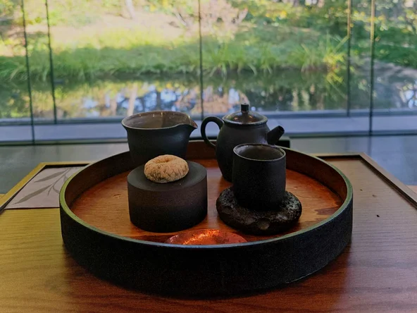 Tea tray with a ceramic teapot, cups and traditional Korean rice cake snack