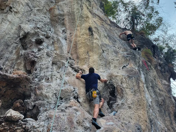 Two men climbing a cliff-face in Krabi