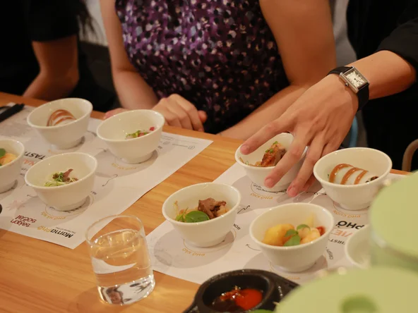 A table full of small sample bowls, filled with different types of pho noodle dishes
