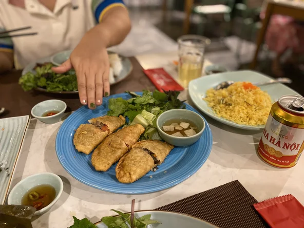 A guide points to food on a table as they explain the multiple dishes laid out