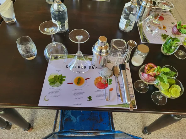 A table set up for a cocktail workshop with glasses and ingredients around a placemat