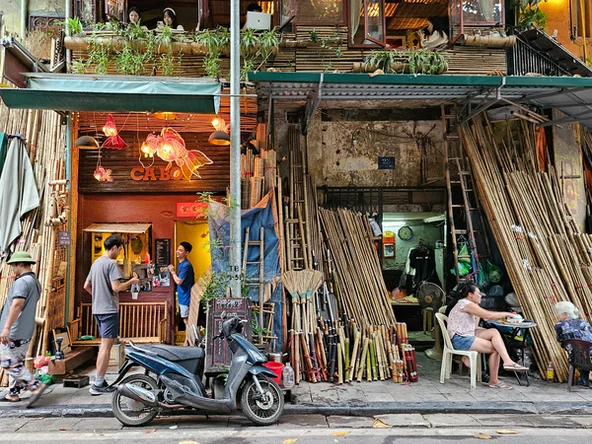A cafe in Hanoi on the second floor, with a woodshop on the ground floor. The road outside is visible with a motorbike parked in front