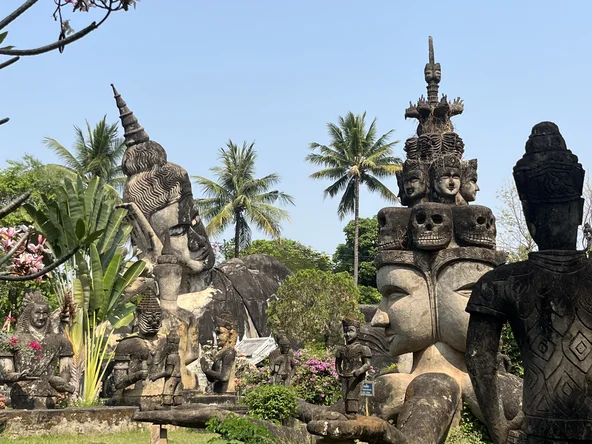 Multiple Buddhist statues collated in a field