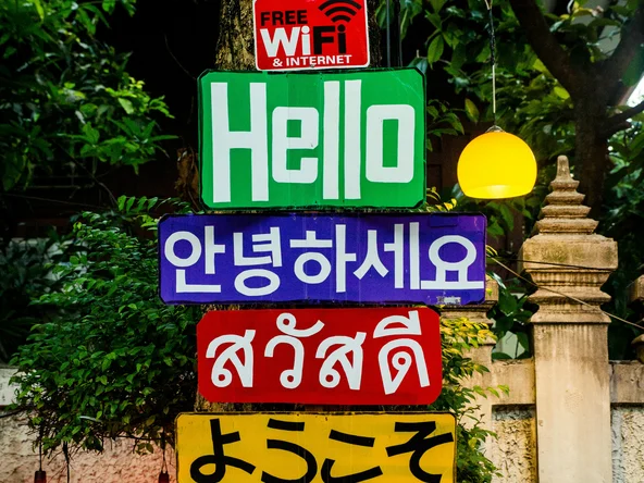 A sign showing the word hello in 4 different languages (English, Korean, Thai, Japanese)