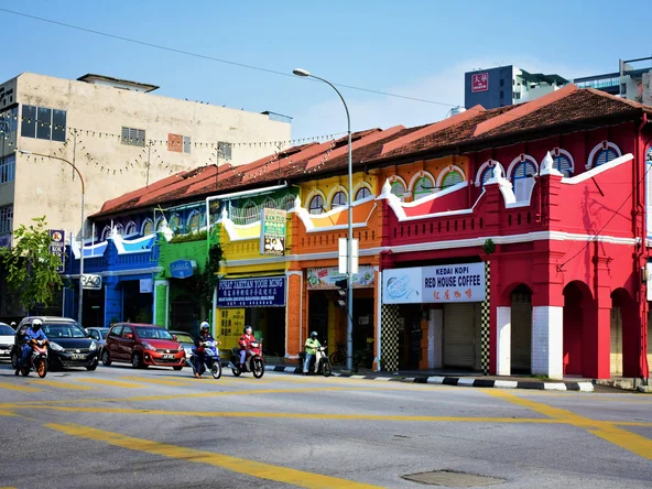 A row of shophouses, each painted a different rainbow colour