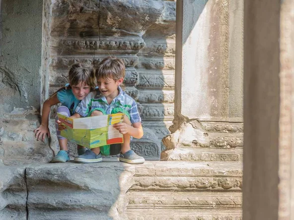 two young children looking at tourist map in Angkor wat, cambodi