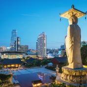 Large Buddha statue of Bongeunsa Temple looking over Seoul skyline at night