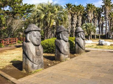Three large rock statues with faces in park
