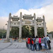 Group of people gathered in front of ornate entrance gate to Po Lin Monastery