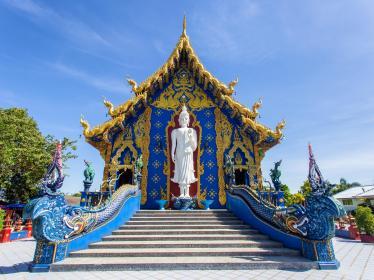 Blue Temple with white Buddha statue at top of stairs