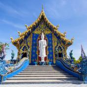 Blue Temple with white Buddha statue at top of stairs