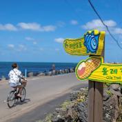 A cyclist enjoys a sunny day along the Olle trail in South Korea's Jeju island