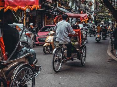 Cyclo riders weaving through busy streets of Ho Chi Minh City