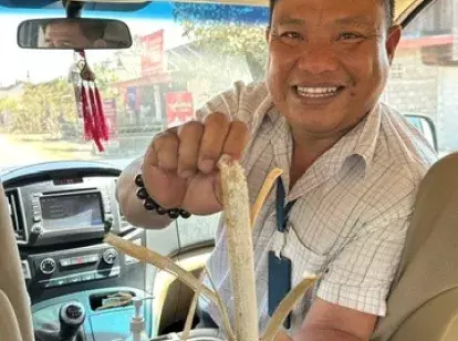 Laos man offering bamboo sticky rice