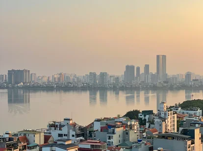 The view of the sun setting warm from a rooftop across truc bach lake in Hanoi, Vietnam in October