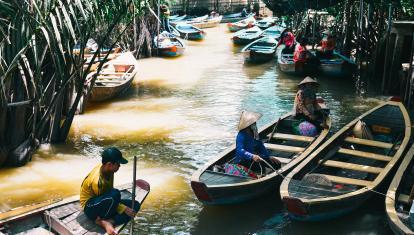 Boats on a narrow stretch of river in the Mekong Delta