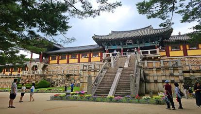 Historic Bulguksa Temple in Gyeongju, South Korea, with a stone staircase and vibrant gardens