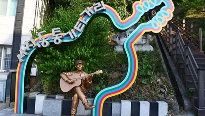 Korean street art of a statue of a bronze man playing guitar