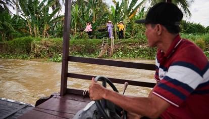 Vietnamese women waving at an incoming man on a boat in the Mekong Delta
