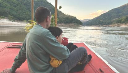 Father and son on boat in Mekong River
