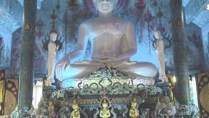 Family kneeling in front of giant buddha statue