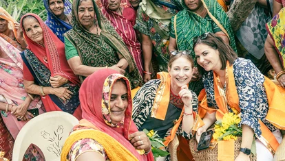 Tourists being welcomed into a photo in India by locals