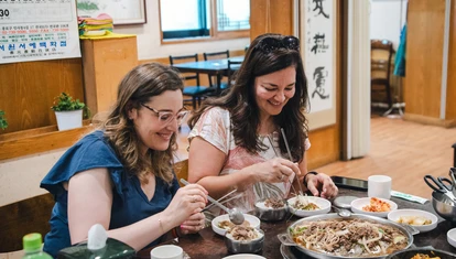 Two competition winners in South Korea eating traditional food