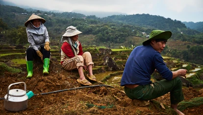 Vietnamese people in the countryside sat amongst rice paddies