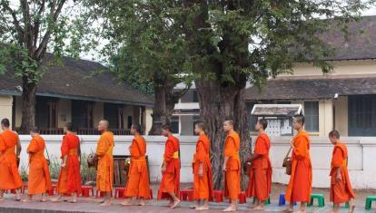 Monks file past during the morning alms