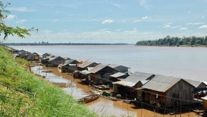 A floating Vietnamese village is anchored to the island by cables.