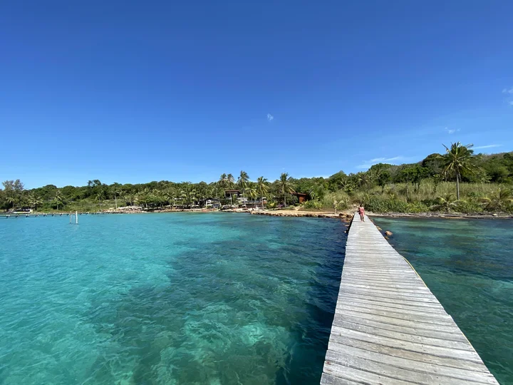 A boardwalk over clear blue waters in Ko Kood, Trat Islands, Thailand