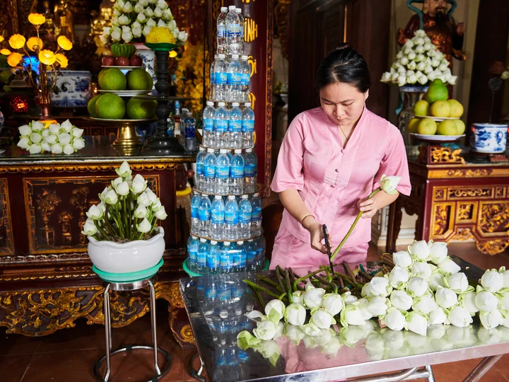 Lady working in a temple in Con Dao, Vietnam preparing lotus flowers for worship