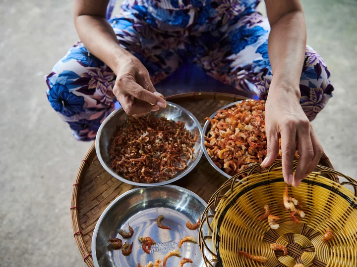 Woman shelling shrimp in Con Dao Vietnam