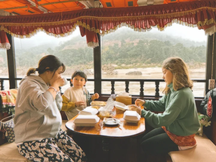 Family enjoying homecooked food on boat in Mekong Delta