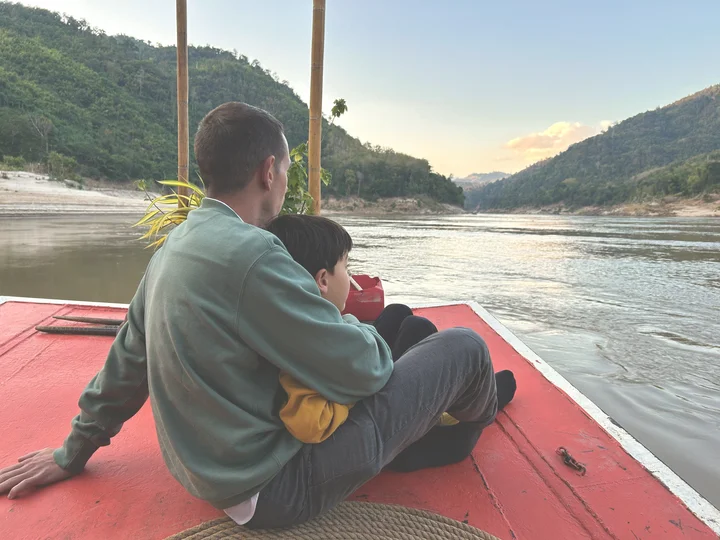 Father and son on boat in Mekong River