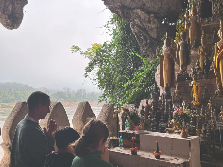 Family praying together at a temple