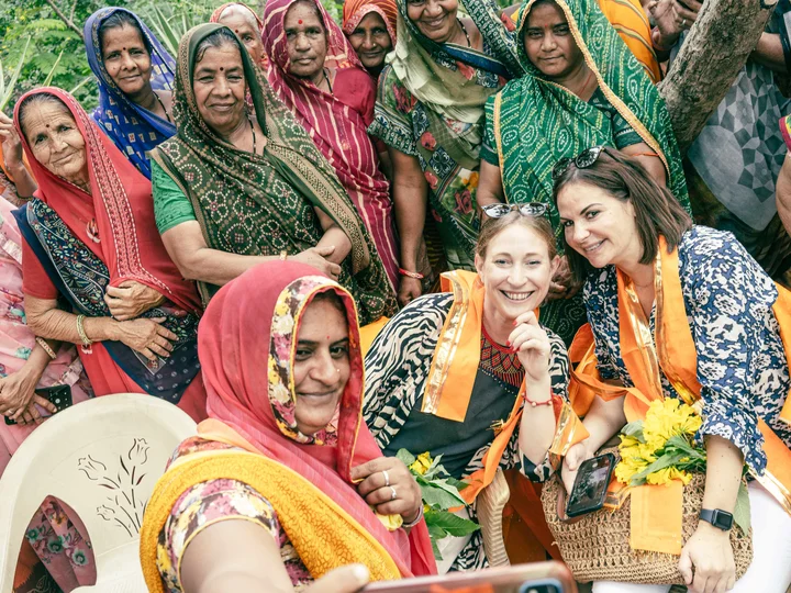 Tourists being welcomed into a photo in India by locals