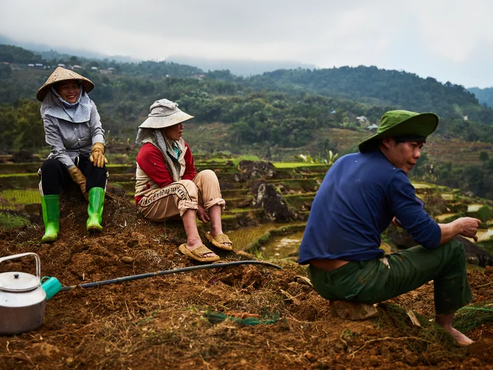 Vietnamese people in the countryside sat amongst rice paddies