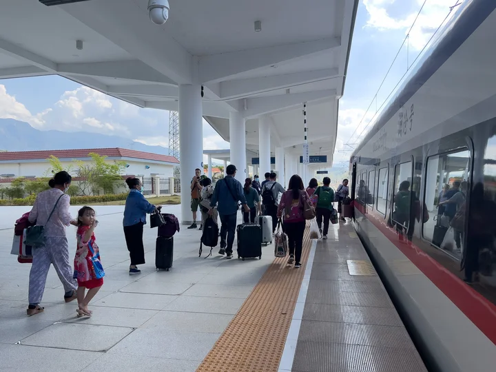 People at a train station in Laos
