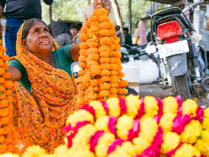 Woman at Indian market selling marigolds
