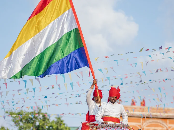 Men waving rainbow flag at Indian festival