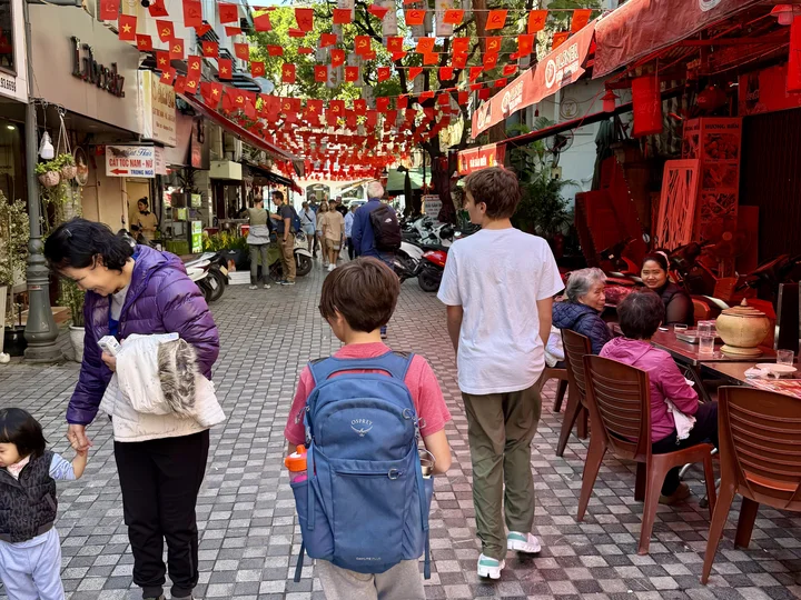 Walking down a street in Hanoi with Vietnamese flags