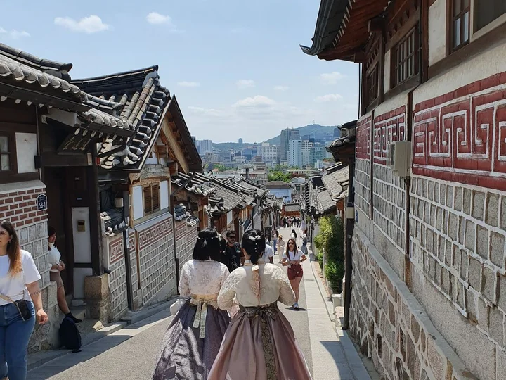 view of bukchon hanok village and two ladies in hanbok