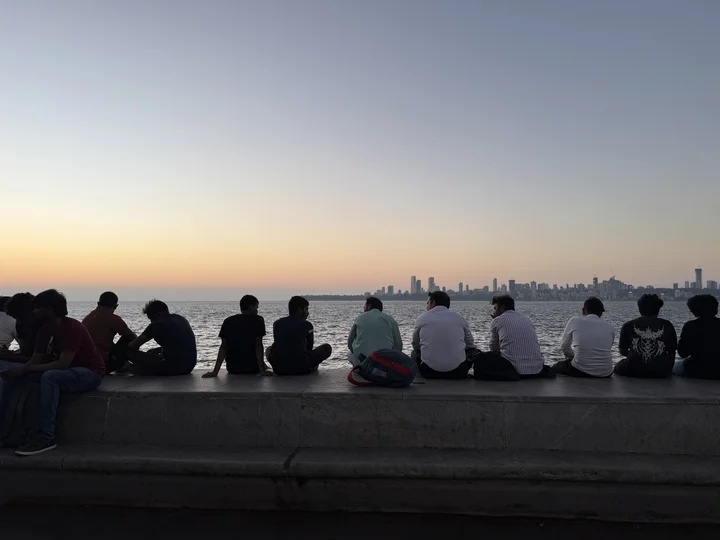 Line of people watching sunset in Mumbai, over Arabian Sea