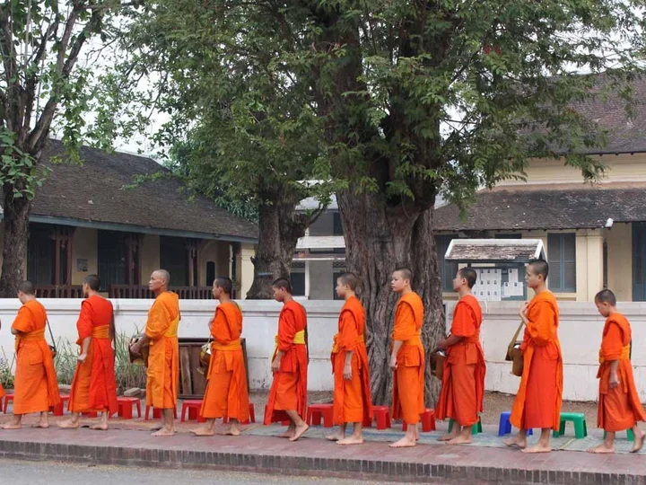 Monks file past during the morning alms