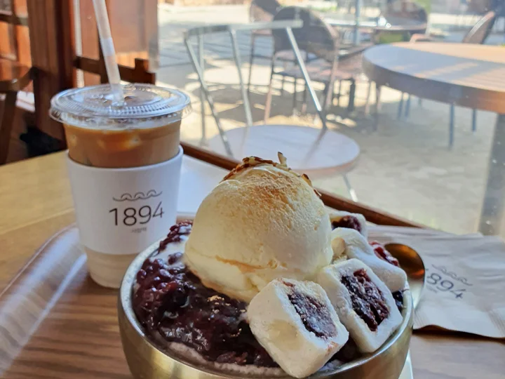 A Korean dessert with ice cream and sweets, with an iced coffee next to it