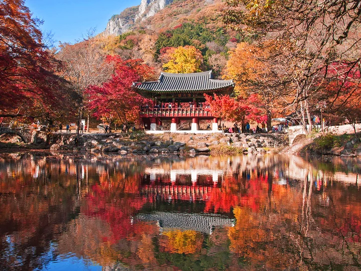 Baegyangsa temple surrounded by autumn colors are reflected on a pond