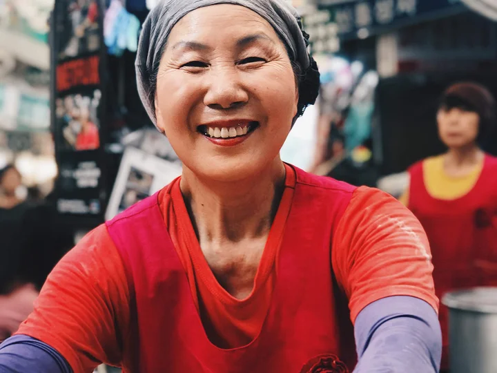 South Korean woman is smiling at the camera in a market in Seoul
