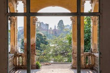An old brick archway partially painted provides beautiful views of royal palance in Phnom Penh